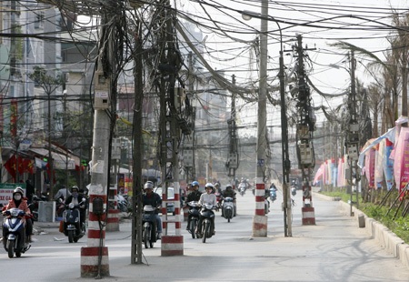 Những cây cột điện “quái dị” trên con đường mới - 5 Có đến hàng chục cột mọc lên thành kiểu hàng rào vắt từ bên này sang bên kia đường.