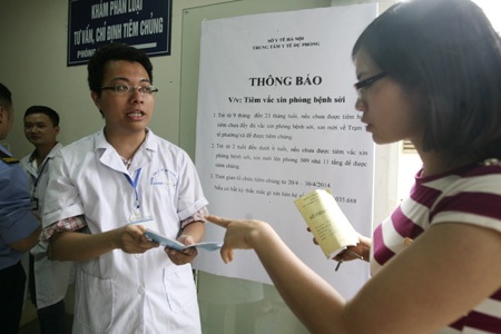 Một nhân viên của TTYTDP đang giải thích về việc tiêm phòng cho người dân.