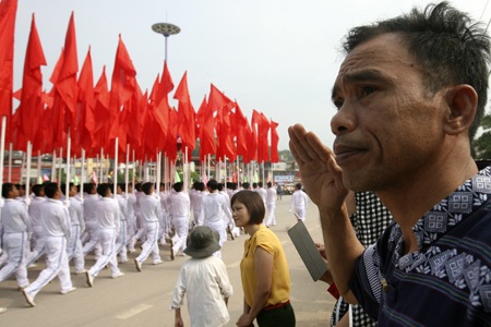 Những cô gái bồng súng diễu binh trên đường phố Điện Biên - 21 Một người dân trang nghiêm chào cờ khi khối hồng kỳ đi qua.