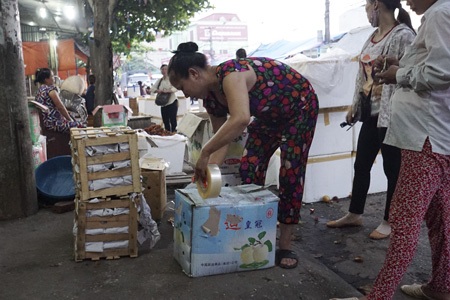 Chợ Giang - Đầu mối nông sản Trung Quốc - 8 Một chủ hàng đang đóng gói lại hoa quả sau khi đã mở ra cho khách xem, chọn.