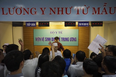 Bồng bế xếp hàng chờ tiêm phòng cho trẻ - 12 Cảnh chen chúc làm thủ tục cho con tiêm phòng.