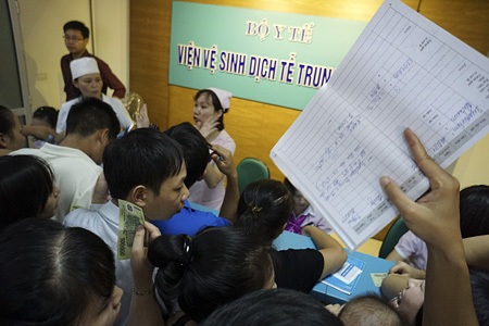 Bồng bế xếp hàng chờ tiêm phòng cho trẻ - 13 Rất nhiều người phải cho con cháu ra đứng ngoài cửa vì không khí ngột ngạt bên trong.