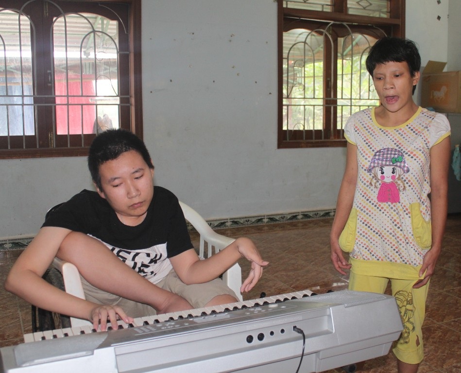 Tùng đang chơi đàn cho một bạn cùng lớp hát