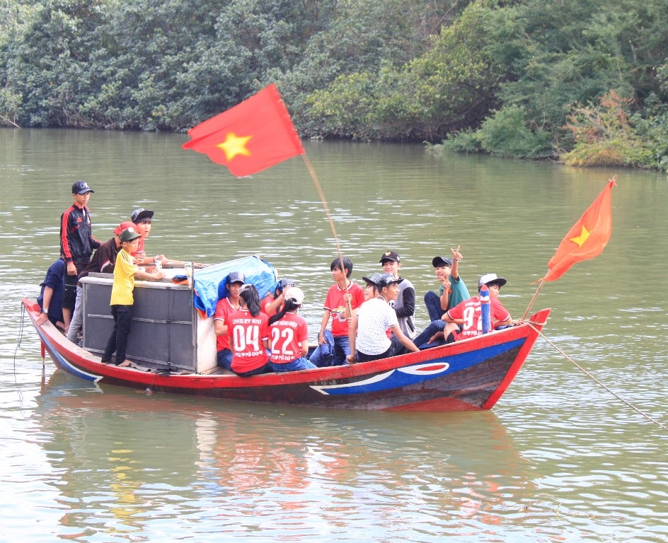 Dưới sông một số cổ động viên nhí cổ vũ nhiệt tình cho các đội thi