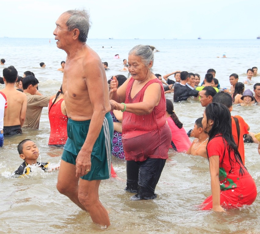 Một cặp vợ chồng già vẫn không quên tục lệ tắm biển ngày này