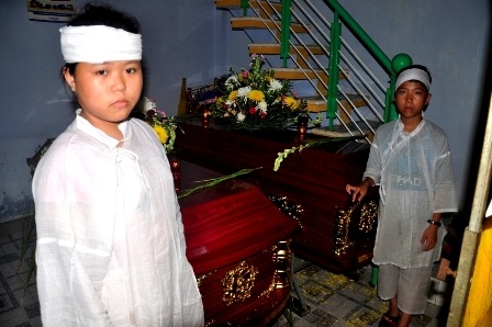 Hai cháu Anh Ngọc và Nguyên Ngọc bên quan tài của ba mẹ