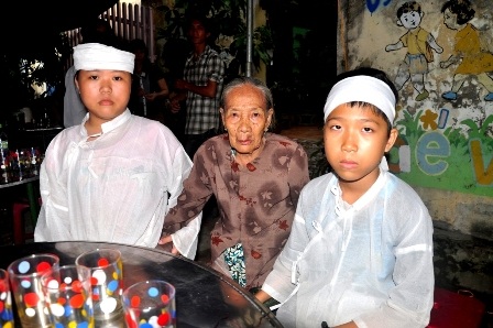 Hai cháu Anh Ngọc và Nguyên Ngọc bên quan tài của ba mẹ