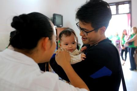 Ca sĩ, nghệ sĩ cùng tổ chức làm từ thiện dịp cuối năm - 4 Ca sĩ Hà Anh Tuẫn bế một em bé tại trung tâm