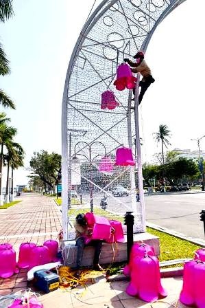 Công nhân hoàn tất việc gắn những hoa đào chuông để trang trí