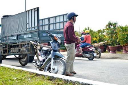Nhọc nhằn nghề chở hoa cuối năm - 1 Một người chở hoa đang đứng tìm khách ở chợ hoa TP Tam Kỳ, Quảng Nam
