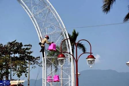 Công nhân hoàn tất việc gắn những hoa đào chuông để trang trí