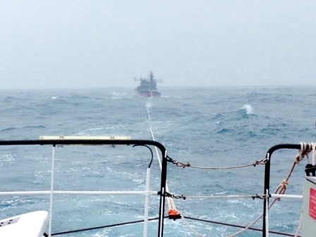 Tàu cứu hộ đang lai dắt tàu của ngư dân bị nạn vào bờ