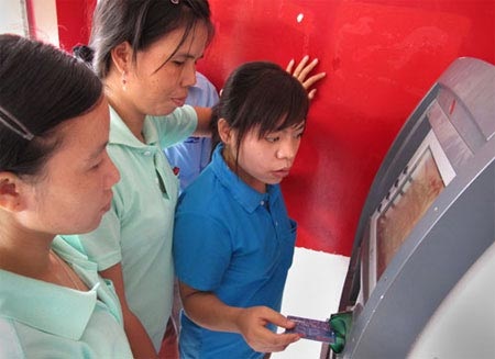 Đầu tư ATM thu lãi "khủng", không lỗ như công bố - 1 Chờ rút tiền bên máy ATM.