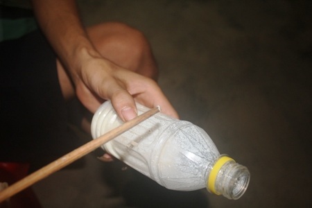 Một sinh vật được cho là đỉa có trong sữa, đang bám ở đầu đũa.