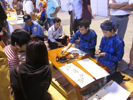 Ông đồ tặng chữ cho khách hàng tại phiên chợ đêm