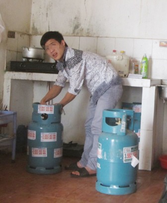 Một nhân viên tiếp thị gas không đồng phục đang kiểm tra van gas.