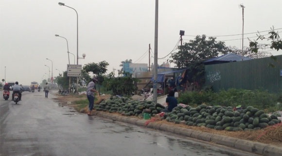 Dưa hấu ê hề vỉa hè, bán tống bán tháo 6.000đ/kg - 2 Dùng chổi quét cho sạch dưa, sau 1 đêm vứt lăn lóc trên vỉa hè Đại lộ Thăng Long
