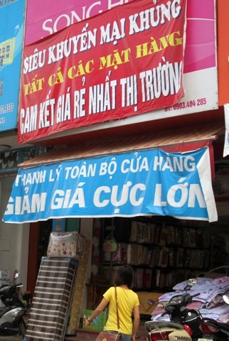 Cửa hiệu bán chăn, ga, gối đệm với băng rôn cam kết rẻ nhất thị trường.