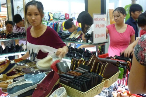 Mắc bẫy với “sale off” - 1 Những chiếc ví, túi xách, giày dép được trưng bảng giảm giá ở siêu thị BigC. Ảnh Uyên Chi