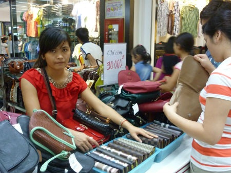 Mắc bẫy với “sale off” - 2 Những chiếc ví, túi xách, giày dép được trưng bảng giảm giá ở siêu thị BigC. Ảnh Uyên Chi