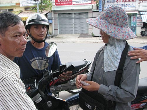 Cặp đôi lừa đảo (hai người ngoài bìa) bị bắt sáng 17/10 với 3 chiếc iPhone giả