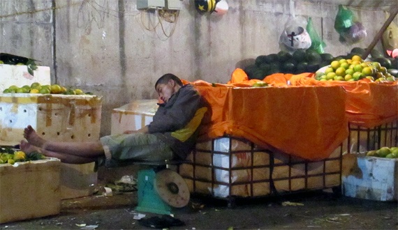 Phiên chợ “ngủ gật” ở Hà Nội - 2 Chủ sạp hàng này không có bất kì chỗ nào có thể ngả lưng, trừ chiếc cân đồng hồ của mình.