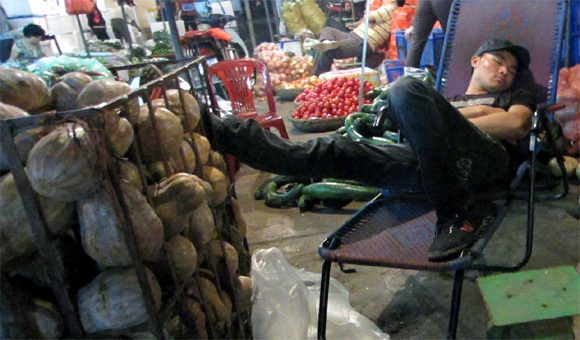 Phiên chợ “ngủ gật” ở Hà Nội - 3 Chủ sạp hàng này không có bất kì chỗ nào có thể ngả lưng, trừ chiếc cân đồng hồ của mình.