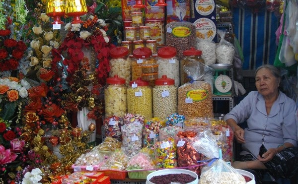 Cuối năm, buôn bán ế ẩm - 1 Bà Thủy chợ Nguyễn Tri Phương, quận 10, TPHCM ngồi rầu rĩ bên gian hàng bánh kẹo đang ế ẩm.