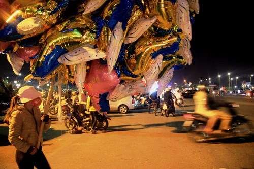 Nhọc nhằn mưu sinh đêm 30 Tết - 1 Giữa phố thị tấp nập không ít mảnh đời trăn trở mong bán từng
quả bóng bay