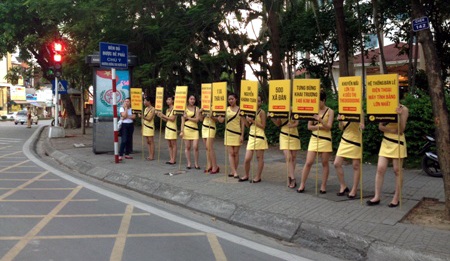 PG cầm biển quảng cáo tại ngã tư (ảnh N.A)
