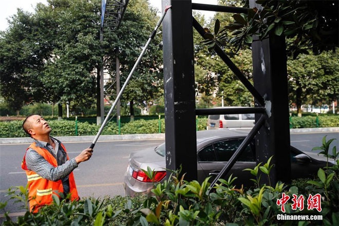 Lạ lẫm hàng trăm triệu phú chọn nghề quét rác - 6 Wang Demin, 55 tuổi, quét dọn đường phố bên cạnh xế sang của cô. Cô xài ôtô riêng đi làm đã 10 năm.