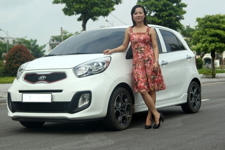 Chị Thanh Hòa chụp ảnh bên chiếc xe Ô tô Kia Morning 1.0 AT 2013