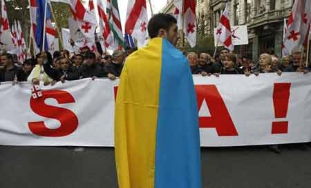 Gruzia: Biểu tình rầm rộ phản đối Nga và chính quyền - 1 Một người Gruzia mang cờ Ukraine tham gia biểu tình phản đối Nga (Nguồn: AP)