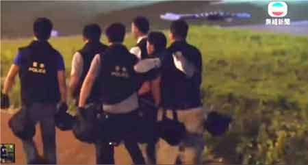 Hong Kong bắt 7 cảnh sát đánh người trong "góc tối" - 1 Nhóm cảnh sát liên quan đang khiêng ông Tăng Kiến Siêu ra “góc tối” (ảnh cắt từ clip của TVB)