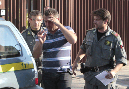 Cảnh sát áp giải một trong những kẻ bị bắt giữ (ảnh: AFP/TTXVN)  