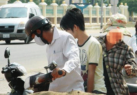 Cảnh sát Campuchia giải thoát 10 người Việt bị tra tấn - 1 Một con bạc được mẹ áp tải ra khỏi casino ở Campuchia sau khi nộp tiền chuộc (ảnh tư liệu)