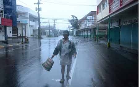 Bão Hagupit đã làm ít nhất 4 người thiệt mạng ở Philippines - 2 Một người đàn ông bước đi trong mưa gió ở Legazpi (ảnh: AFP)