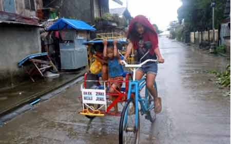 Bão Hagupit đã làm ít nhất 4 người thiệt mạng ở Philippines - 3 Những đứa trẻ băng qua đường phố Dolores dưới cơn gió mạnh mẽ (ảnh: AFP)
