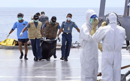 Các thợ lặn lần đầu tiên vào được bên trong thân máy bay QZ8501 - 1 Một thi thể được các thợ lặn vớt lên (ảnh AFP)