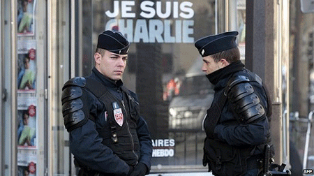 Đang đà bán chạy, Charlie Hebdo bất ngờ…hoãn phát hành - 1 Cảnh sát canh phòng bên ngoài tòa báo Charlie Hebdo (ảnh: AFP)