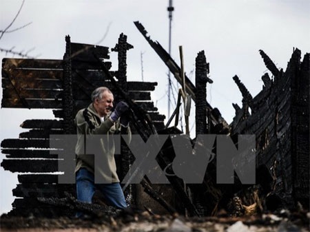 Ukraine chính thức cấp quy chế đặc biệt cho khu vực miền Đông - 1 Người dân địa phương thu dọn căn nhà bị đổ nát trong xung đột tại Donetsk ngày 6/4 vừa qua. (Ảnh: