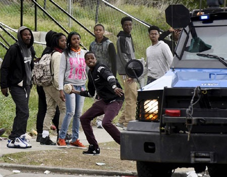 Một người dân ném đá về phía cảnh sát