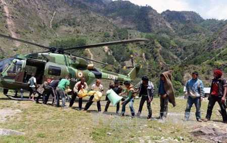 Nepal đưa hàng cứu trợ động đất tới khu vực hẻo lánh - 1 Người dân Nepal nhận hàng viện trợ từ máy bay quân đội Ấn Độ tại quận Gorkha ngày 4/5. (Ảnh: