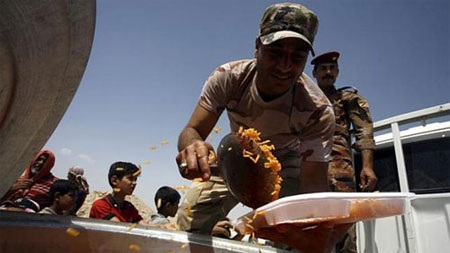 Iraq chìm sâu vào bất ổn an ninh - 1 Nhân viên Chính phủ Iraq phân phát thực phẩm cho người tị nạn ở thành phố Falluja. (Ảnh: