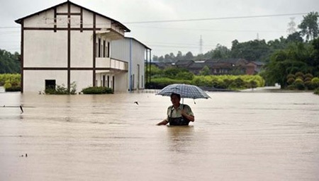Mưa lũ “hiếm có” trong lịch sử Trung Quốc, 108 người chết - 1 Một người đàn ông cầm ô lội nước ở Trùng Khánh hôm 30/6