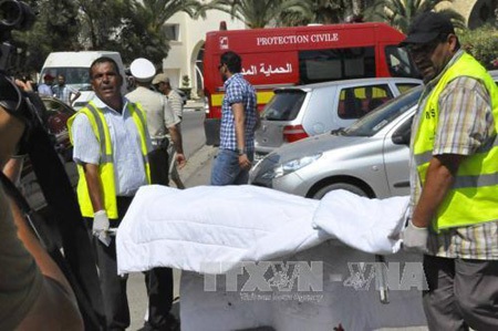 Lực lượng cứu hộ Tunisia chuyển thi thể một nạn nhân sau vụ xả súng. (Ảnh: