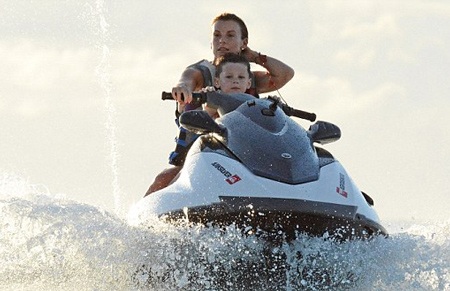 Coleen cưỡi mô tô đưa con trai đi chơi trên biển.