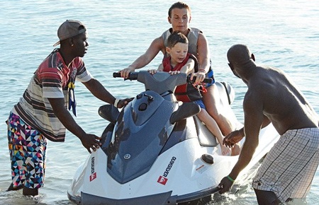 Coleen cưỡi mô tô đưa con trai đi chơi trên biển.