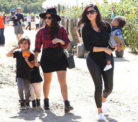 Kim bế con gái Nori trong khi chị gái Kourtney của cô dẫn theo hai đứa con đi dạo quanh công viên.