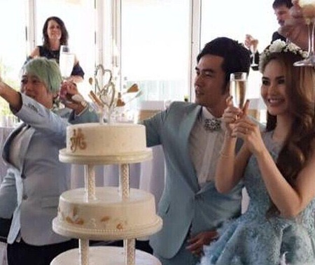 Cặp đôi cùng cắt bánh cưới và nâng ly chúc mừng hạnh phúc với bạn bè, người thân.